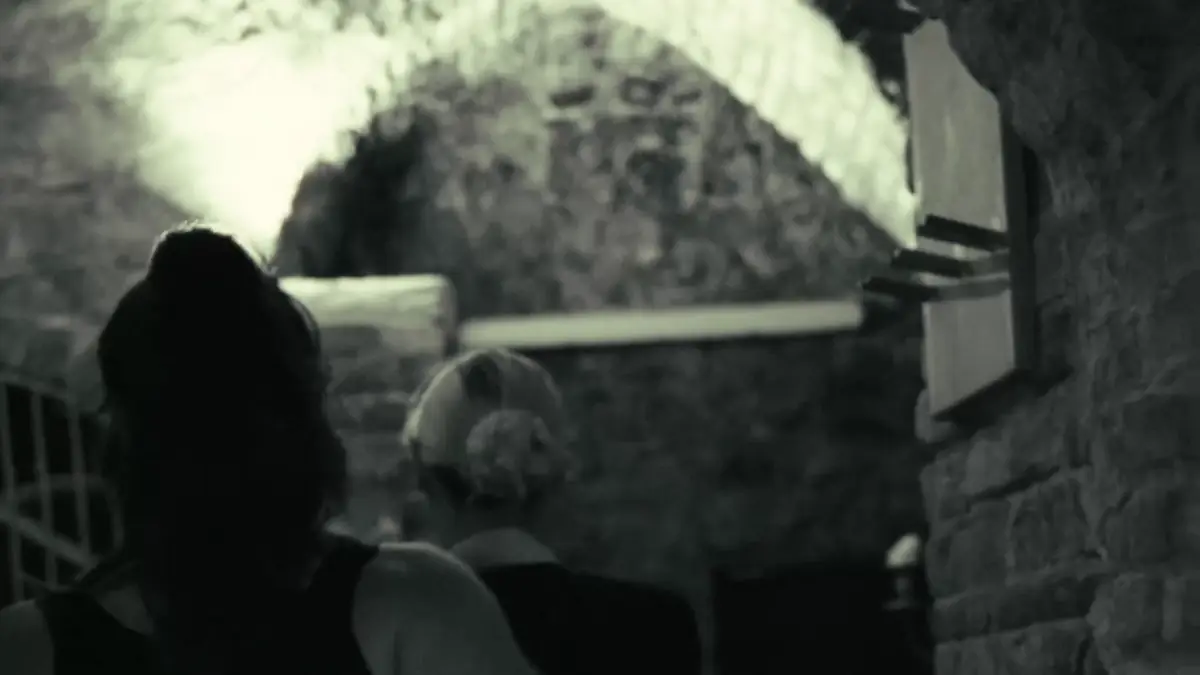 Zwei Personen gehen unter einem Gewölbe in einen alten Keller – Standbild aus einem Film von Secret Mission