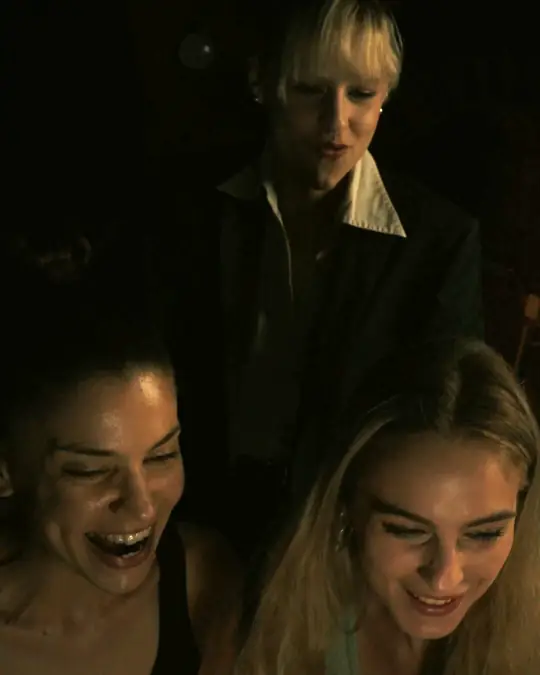 Zwei Spielerinnen lachen, hinter ihnen steht eine Agentin – Standbild aus dem Film zur Mission NOVEX-3