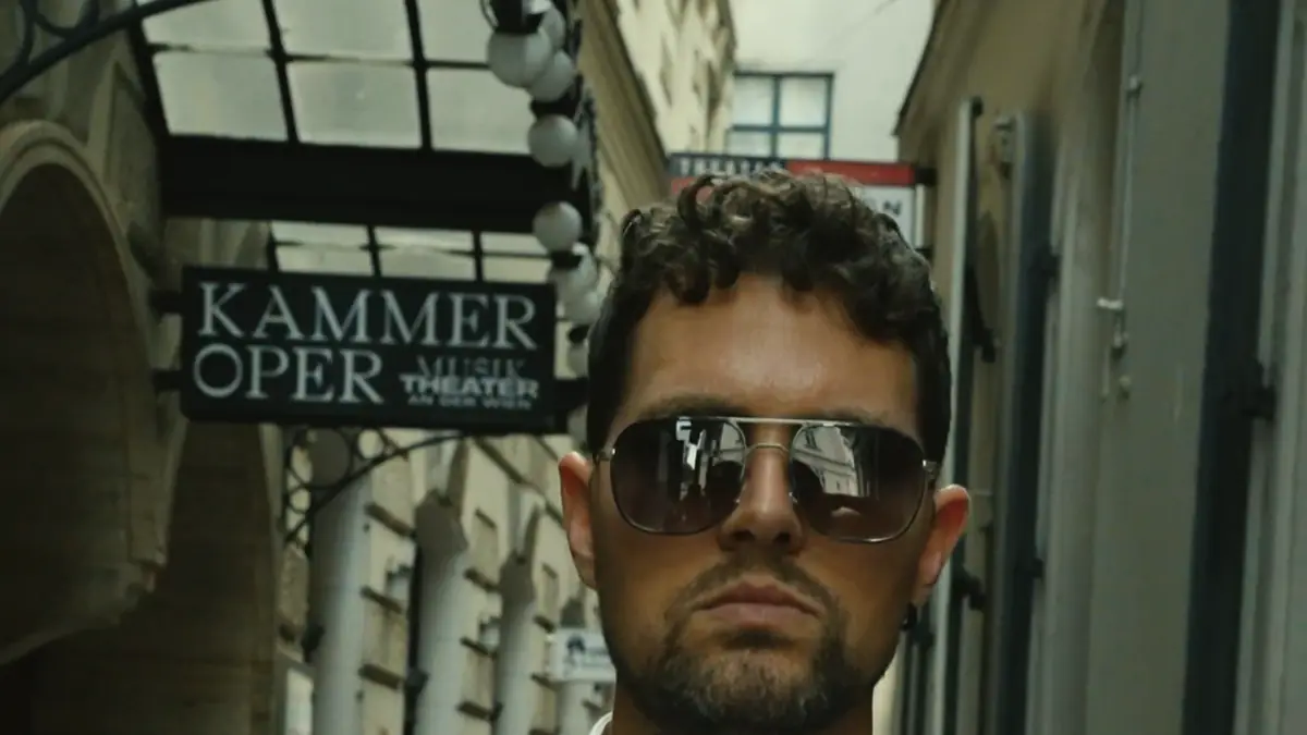 Ein Mann im Anzug mit Sonnenbrille in einer Gasse der Wiener Innenstadt – Standbild aus einem Film von Secret Mission