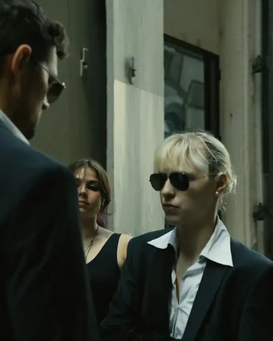 Two agents meet a man in a suit in a narrow lane