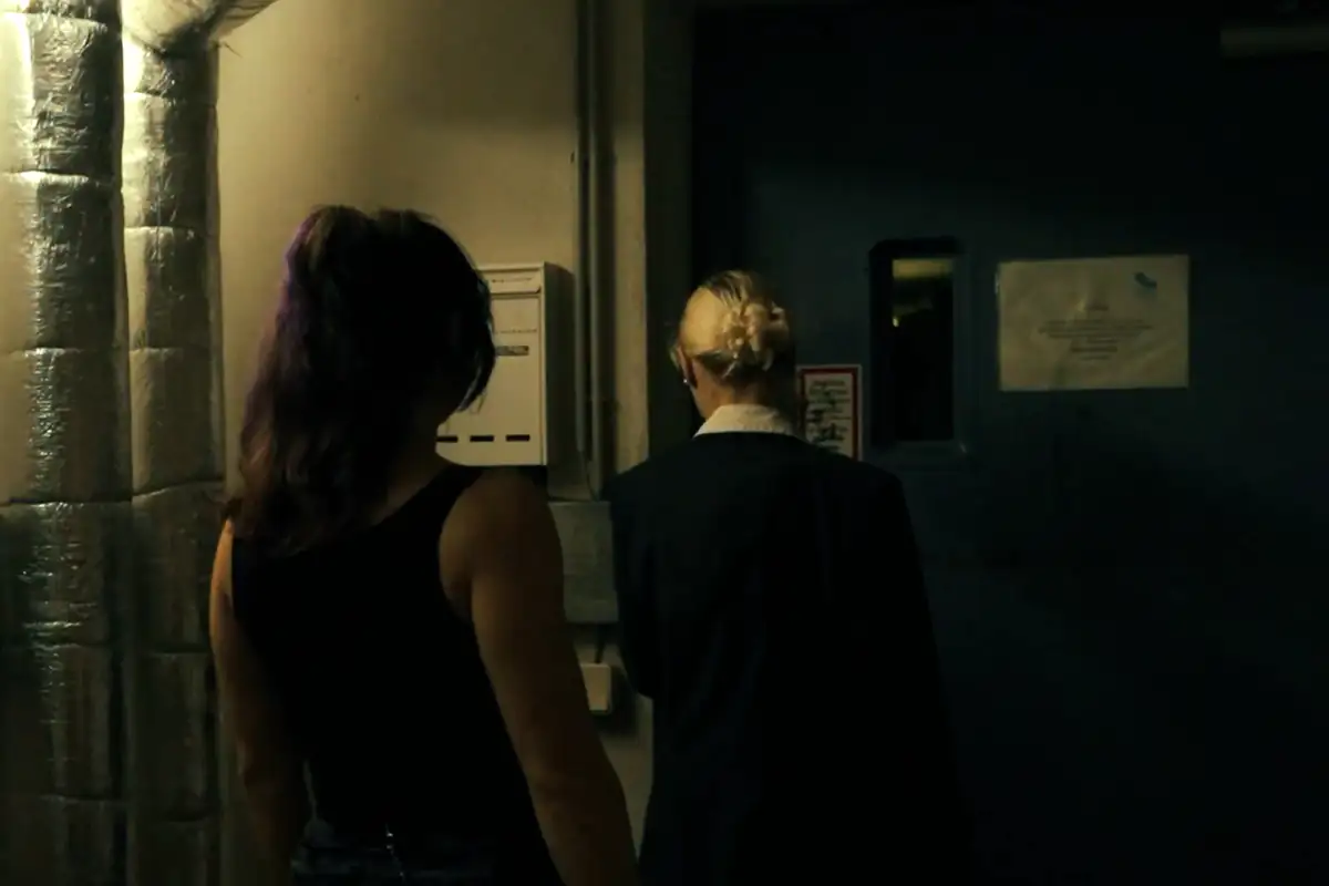 Due agenti percorrono un corridoio sotterraneo verso una porta d’acciaio – fotogramma di un film di Secret Mission