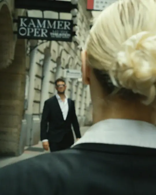 Ein Mann im Anzug kommt einer Agentin in der Gasse vor der Kammeroper entgegen – Standbild aus einem Film von Secret Mission