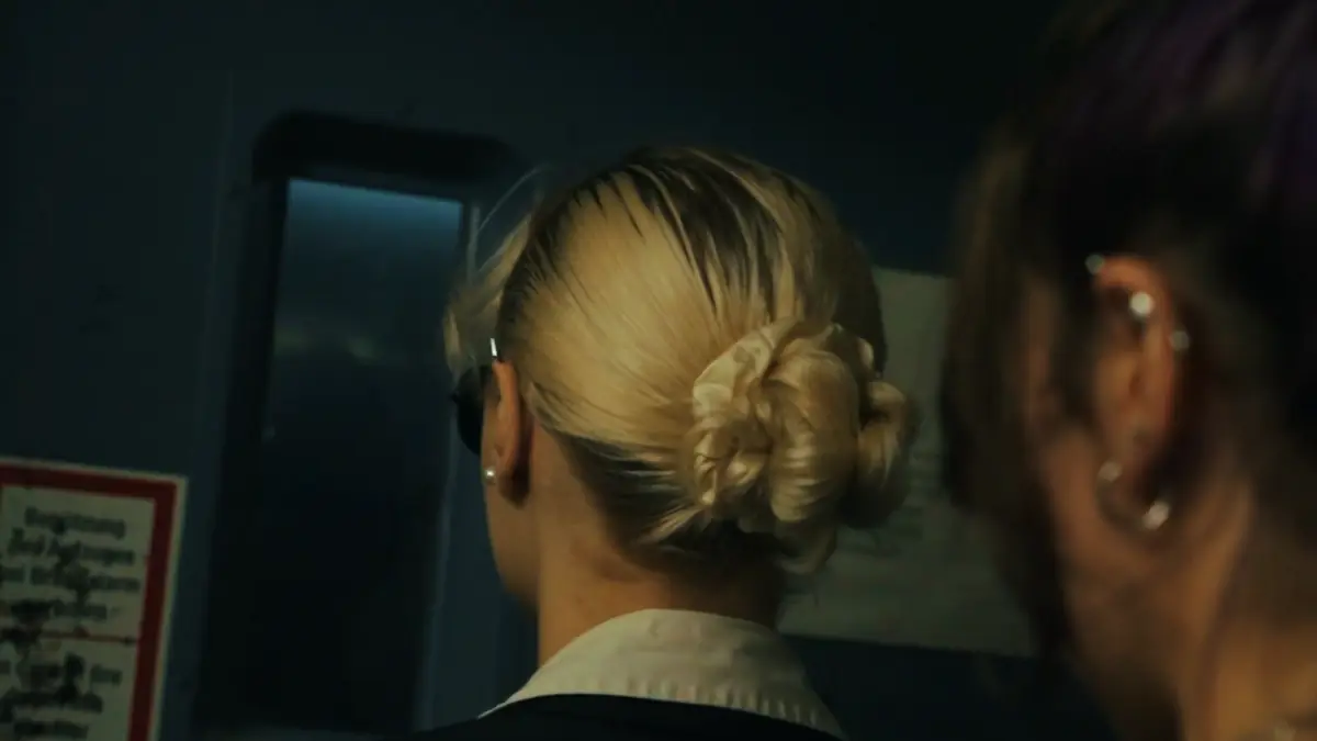 Zwei Ermittlerinnen lesen an einer blauen Stahltür einen Aushang – Standbild aus einem Film von Secret Mission